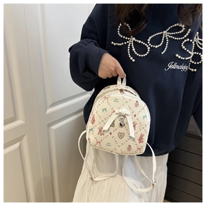 Close-up of mini PU leather backpack with pink bear prints and heart metal charm