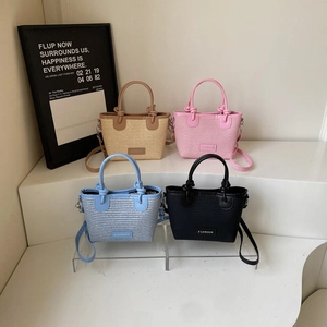 Woven straw bucket bag with fashion label and shoulder strap in four assorted colors