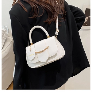Nahaufnahme der weißen Lederhandtasche mit goldenem Metallstab und zylindrischem Griff