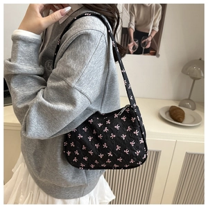 Detail of black floral shoulder bag with pink bow embroidery and metallic silver zipper