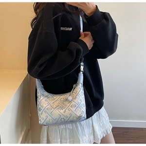 Detailaufnahme der blauen Stickerei und der silbernen Schnalle der Schultertasche