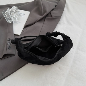Detailed top view of black cloud bag with knot design and interior zip pocket