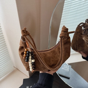 Detail of coffee brown suede hobo bag with knotted strap and colorful beaded tassel