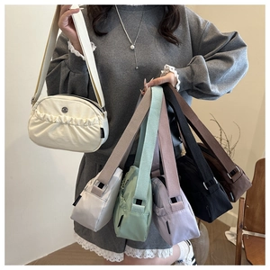 Detail showing various colors of pleated crossbody bags with adjustable straps