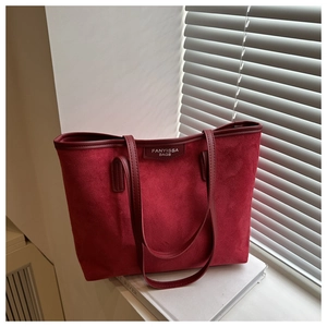 Close-up of red matte tote bag with textured surface on a minimalist indoor windowsill