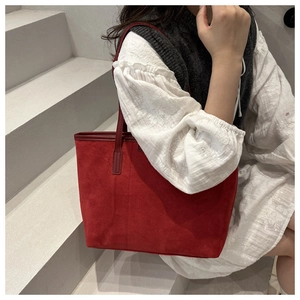 Close-up of red suede tote bag showing premium matte texture and dual shoulder straps