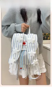 Detail of blue striped canvas backpack with plush stars and drawstring closure