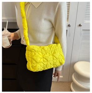 Gros plan d'un sac bandoulière jaune néon matelassé avec des bretelles bouffantes