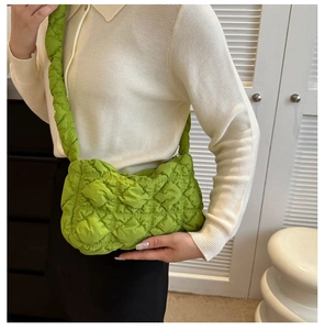 Détail d'un sac matelassé vert vif avec une texture froncée et une bandoulière souple