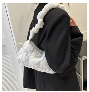 Vue détaillée du sac nuage blanc matelassé avec bandoulière plissée sur l'épaule