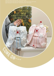Detail of cute striped backpack with plush stars and apple embroidery for school