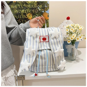 Detail of blue and white striped canvas backpack with plush stars and apple patch