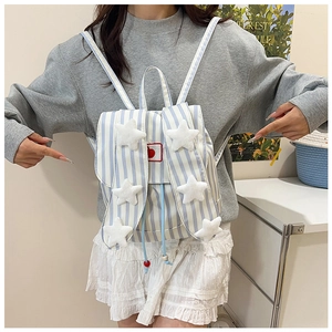 Detail of blue striped canvas backpack with plush stars and drawstring wood bead closure
