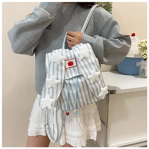 Detail of blue striped backpack with plush white stars and red apple patch on the cover