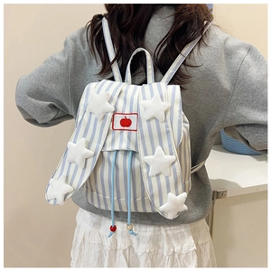 Detail of blue striped backpack featuring plush stars, apple embroidery, and drawstring