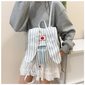 Detail of bunny ear backpack with blue stripes and embroidered red apple patch