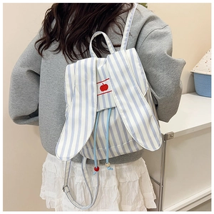 Close-up of cute rabbit ears and apple embroidery on striped canvas girls backpack