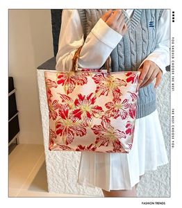 Detail of bamboo handle tote bag featuring vintage red floral pattern on satin fabric