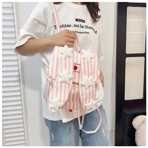 Detail of pink striped school backpack featuring plush stars and cute rabbit ears decoration