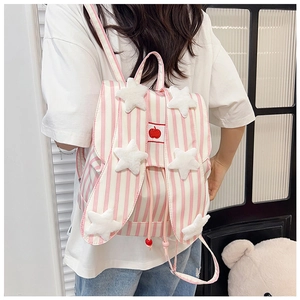 Detail of pink striped backpack with bunny ears and plush star decorations on model