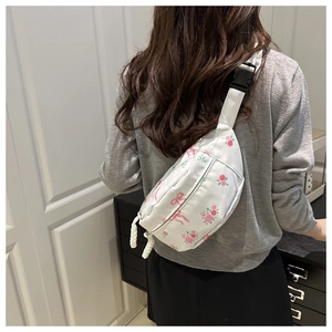 Détail du sac bandoulière blanc avec motifs de roses roses, nœuds et boucle de sangle
