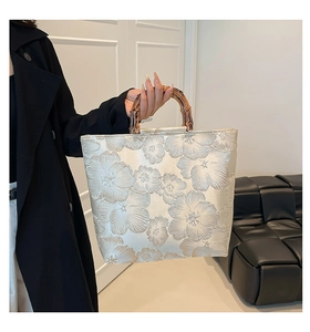 Detail view of floral embroidery tote bag with authentic bamboo handle and jacquard fabric