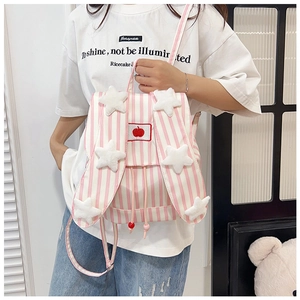 Detail of pink striped backpack with plush stars and red apple embroidery close-up