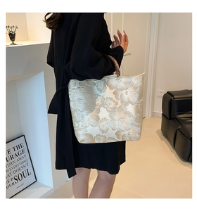 Detailed texture of ivory jacquard tote bag featuring floral patterns and bamboo handle