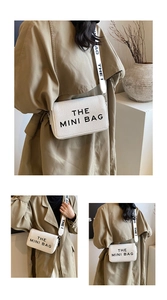Close-up of white pebble leather crossbody bag with bold THE MINI BAG lettering on wide strap