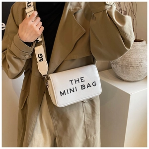 Close-up of white pebble leather mini crossbody bag with wide letter print shoulder strap