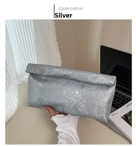 Close-up of silver snakeskin embossed leather clutch bag with minimalist envelope design