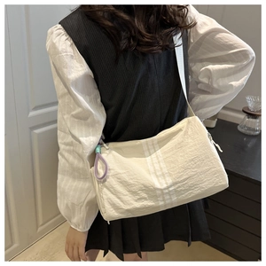 Detail of beige striped nylon yoga bag with purple rope zipper and white shoulder strap