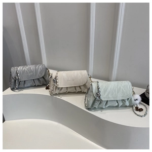 Three pleated crossbody bags in grey, cream white, and mint green with metal chains