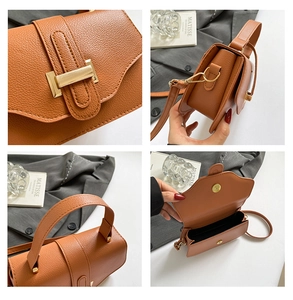 Detail view of brown leather crossbody bag with lychee texture and gold metal buckle