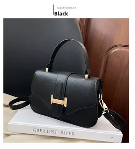 Close-up of black lychee grain leather handbag featuring a golden H-shaped buckle closure