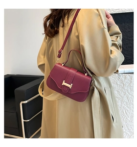 Burgundy litchi grain leather crossbody bag with golden H buckle shown on model