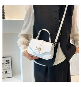 Close-up of white lychee leather square handbag with golden buckle and top handle