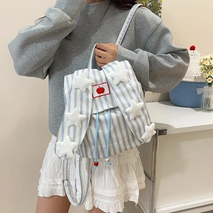Blue and white striped backpack with plush stars and apple patch on a model