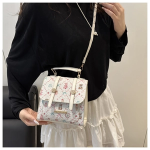 Detailed close-up of a white floral bag with cute bear prints and adjustable shoulder strap