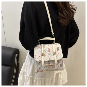 Close-up of white mini handbag with cute cartoon bear prints and metal buckle details
