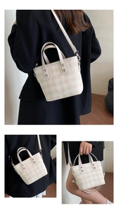 Detailed views of light checkered bucket bag with dual handles and crossbody strap