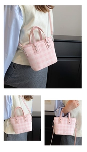 Macro detail of pink checkered bucket bag with leather handle and brand lettering