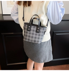 Detailed view of mini checkered bucket bag with silver studs and adjustable strap