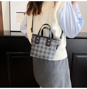 Détail d'un mini sac cabas gris à carreaux doté d'une bandoulière noire réglable