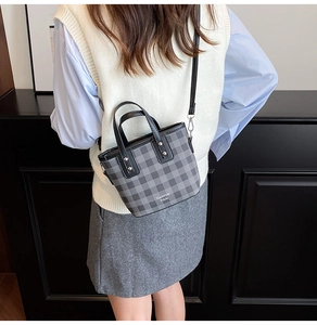 Detailed back view of a woman wearing a checkered mini bucket bag with a slim strap