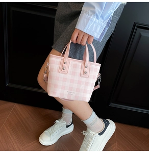 Détail du mini sac seau à damier rose et blanc avec poignées en cuir et bandoulière