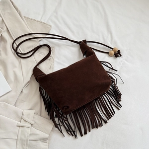Dettaglio borsa hobo in camoscio marrone con frange lunghe e perline di legno sul manico
