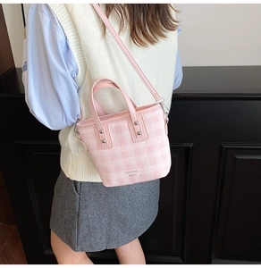 Detailaufnahme der rosa karierten Beuteltasche mit Silbernieten und Schultergurt