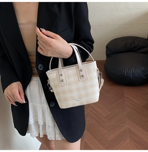 Close-up of beige plaid mini bucket bag with TIANYUN YICAI logo and top handles