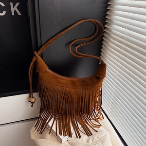 Dettaglio della borsa hobo in camoscio marrone con frange boho e perline di legno